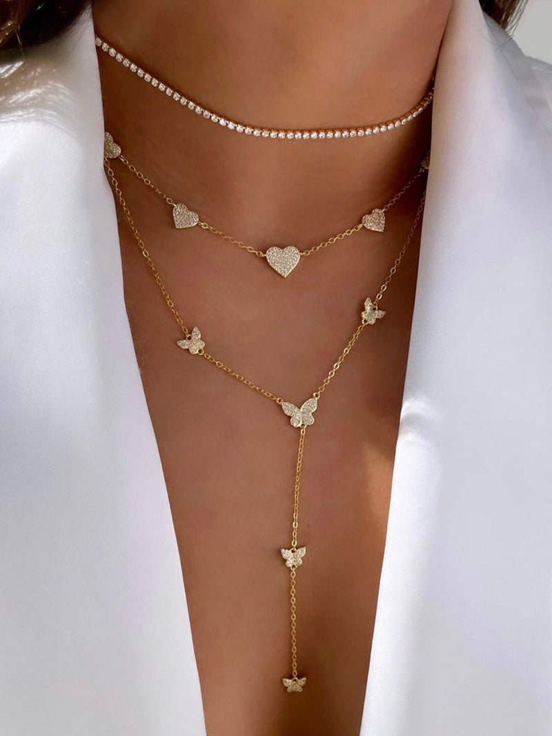 Dit is een goudkleurige Y-lariat ketting versierd met meerdere vlinder- en hartvormige kristallen bedels van het merk Choose by Felice - This is the original butterfly Y chain necklace designed by the brand Choose by Felice 